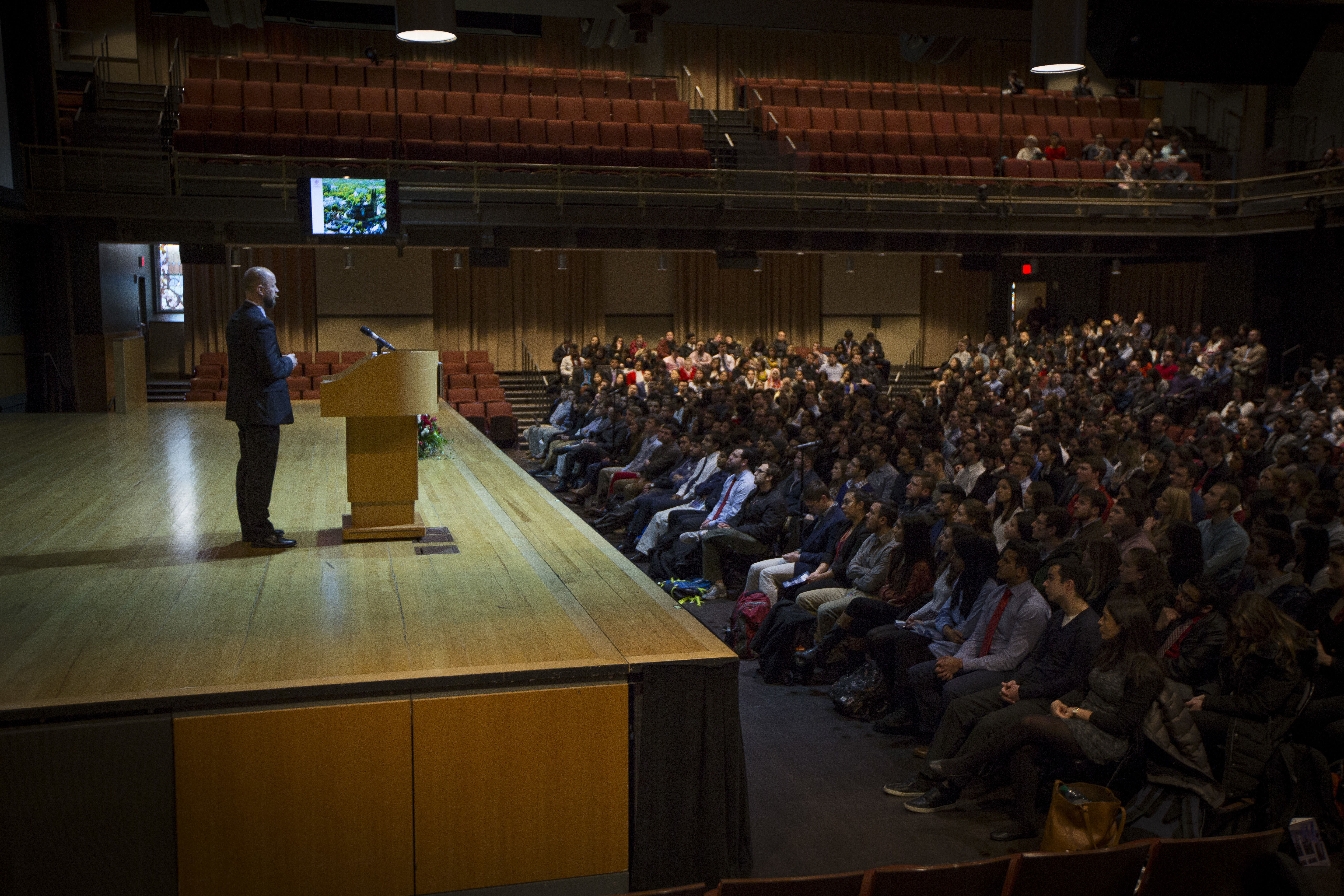 An on-stage speaker addresses the audience during a Research Day event.