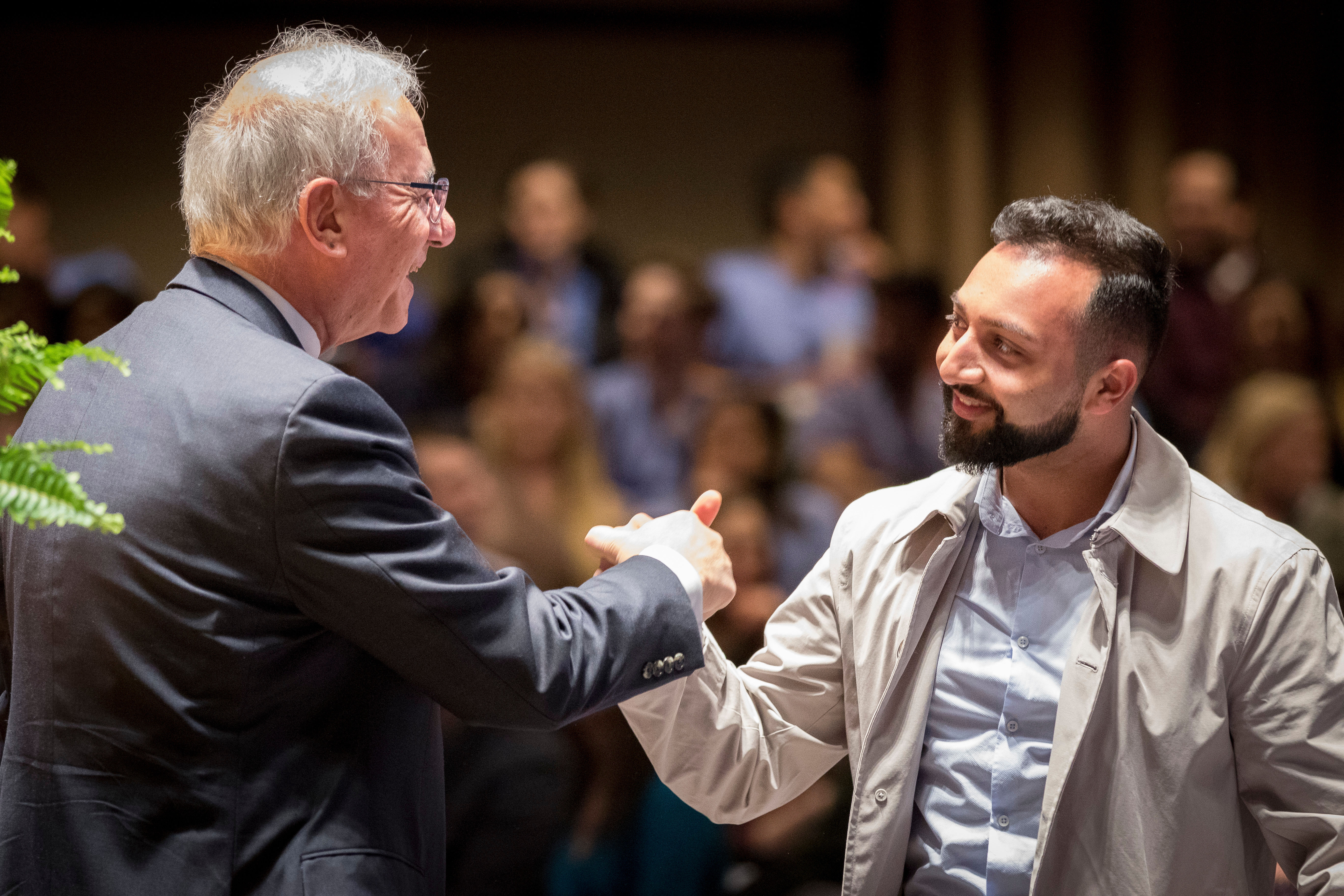 Kornberg Dean Amid Ismail greets a guest during a Research Day event.